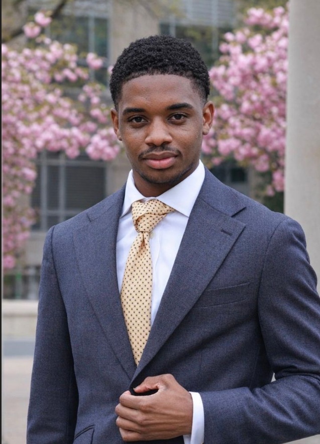 Alfred Lewis Jr., International Vice President of Media Relations and External Affairs, wearing a slate-blue suit and gold polka-dot tie