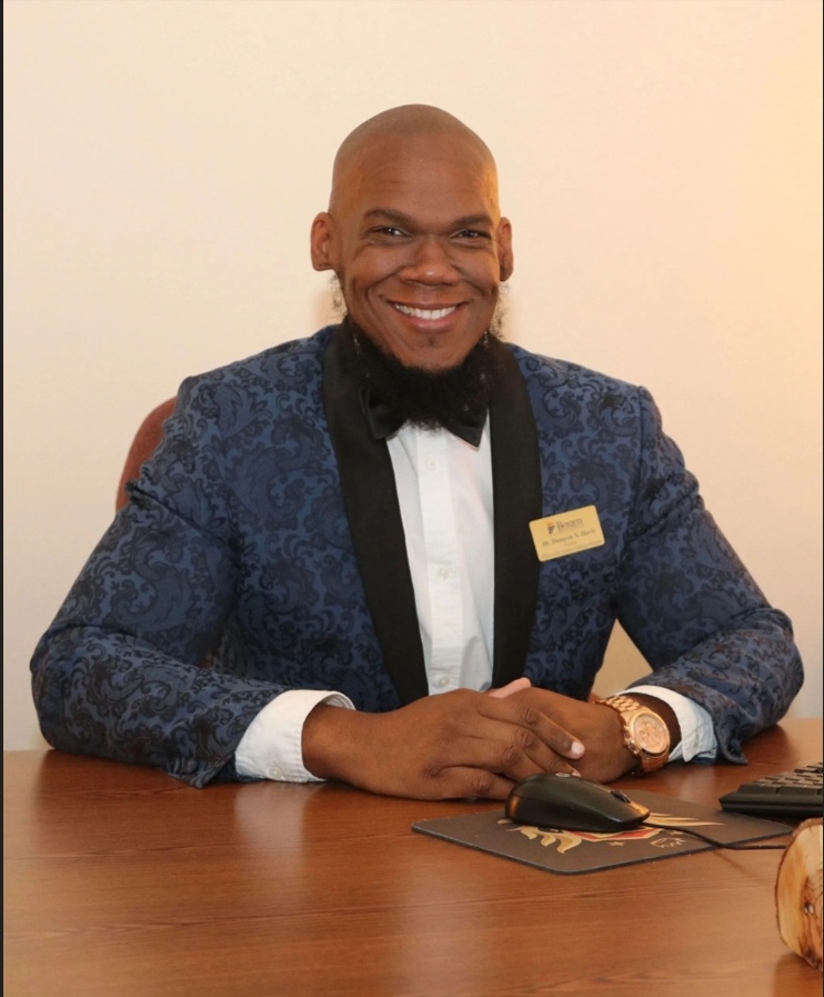 Dr. Damýen Davis, International President of Phi Psi Lambda Leadership Society, Inc., wearing a navy paisley blazer and bow tie