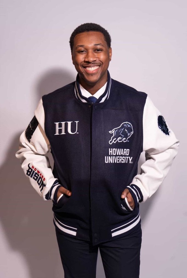 Jeremy Allman of Phi Beta Sigma Fraternity, Inc. at Howard University, wearing a navy and white Howard University varsity letterman jacket